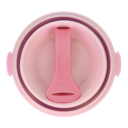 Pink lunch box collapsed with the strap inside, top view.